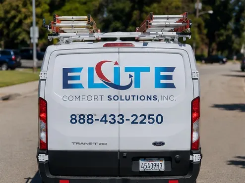Rear of an Elite Comfort Solutions Ford Transit service van with ladder rack