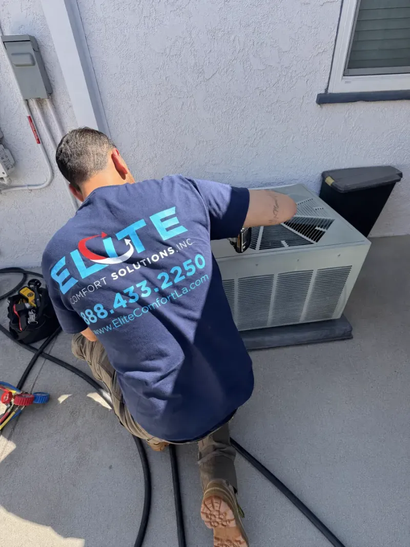 Elite Comfort Solutions technician performing an AC tune-up on a residential package unit